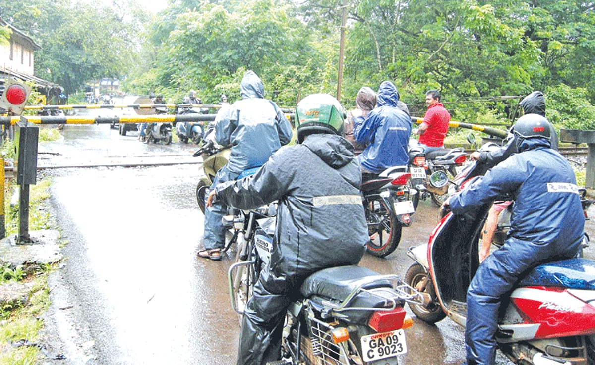 Motorists, including two-wheeler riders, wait at the Guirdolim railway crossing.