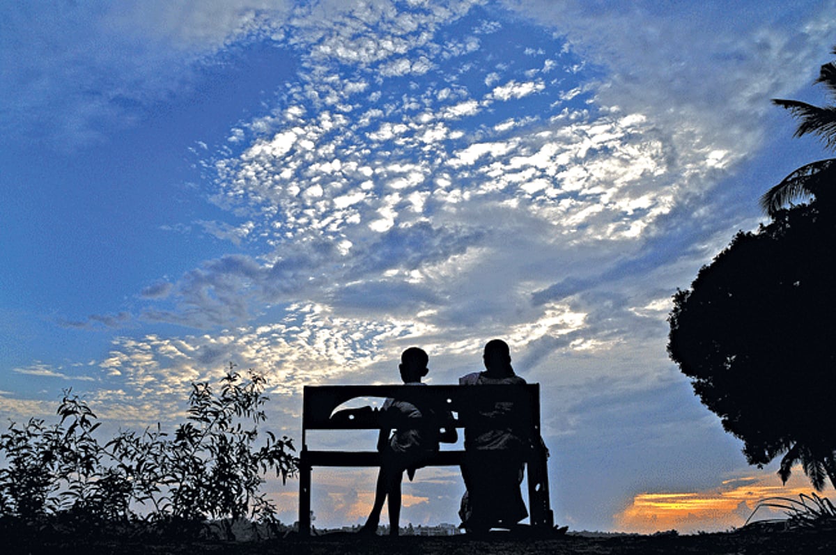 ONE WITH NATURE: A woman and a boy are silhoutted against rain clouds at Saligao on Wednesday evening. The State witnessed showers at many places bringing respite from the soaring temperatures.