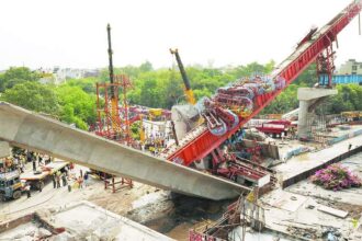 Onlookers and rescue workers gather at the site where a pillar supporting a section of the Delhi Metro carriageway collapsed in New Delhi on Sunday.