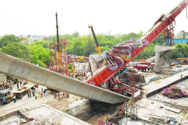 Onlookers and rescue workers gather at the site where a pillar supporting a section of the Delhi Metro carriageway collapsed in New Delhi on Sunday.
