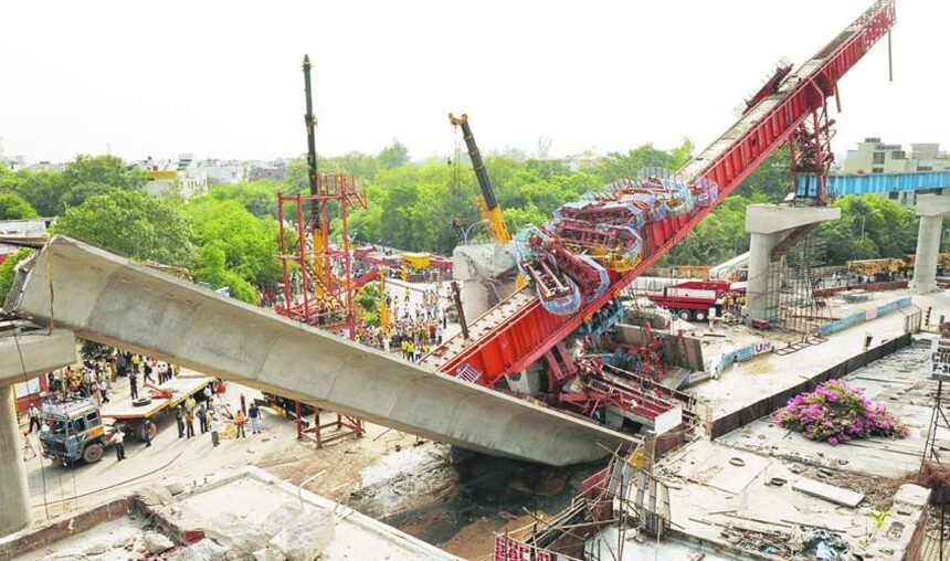 Onlookers and rescue workers gather at the site where a pillar supporting a section of the Delhi Metro carriageway collapsed in New Delhi on Sunday.