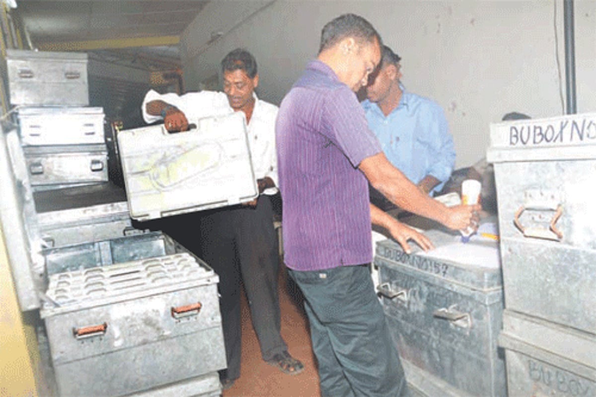 POLL MATERIAL: Poll officials arrange EVMs sealed in trunks at the Goa College of Pharmacy, Panjim on Thursday.