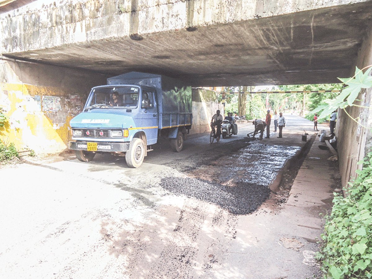 PWD workers in the process of repairing the potholed road below the railway bridge along the Mangor-Vasco route.
