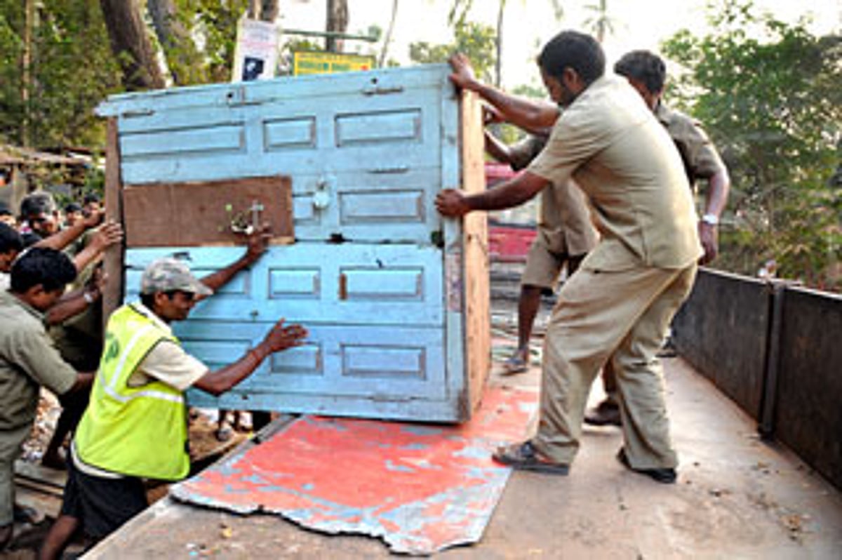 Panjim Corporation workers load a kiosk onto a truck as per the High Court directives