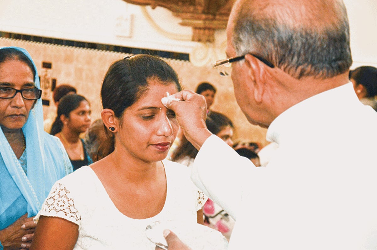 Parish priest of the Immaculate Conception Church in Panjim Fr Cleto Pereira applies ash on the forehead of a devotee on Ash Wednesday, which marks the beginning of the Lent season.