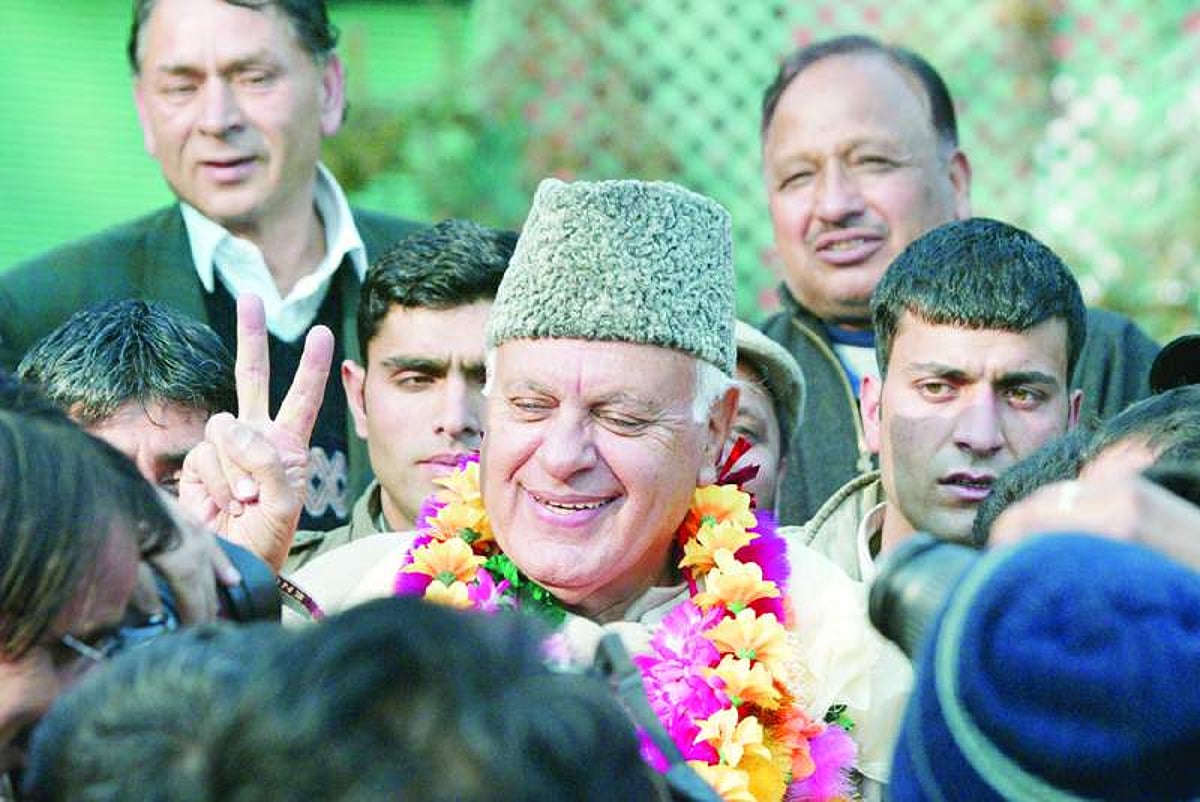 Patron of National Conference party Farooq Abdullah shows a victory sign after winning assembly elections in Srinagar on Sunday.