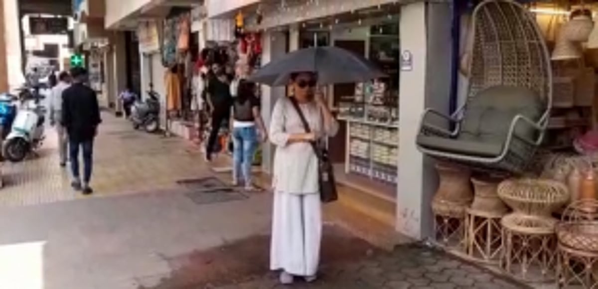 Pedestrians have to bear with water falling on them from air conditioners in the city