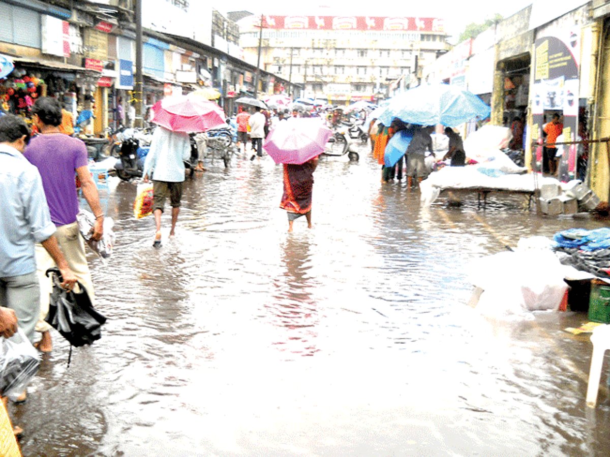 People struggle to walk through the Mapusa Municipal market.