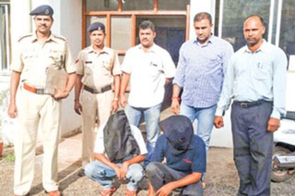 Police along with the two accused (squatting) who have been arrested on charges of molesting a schoolgirl.