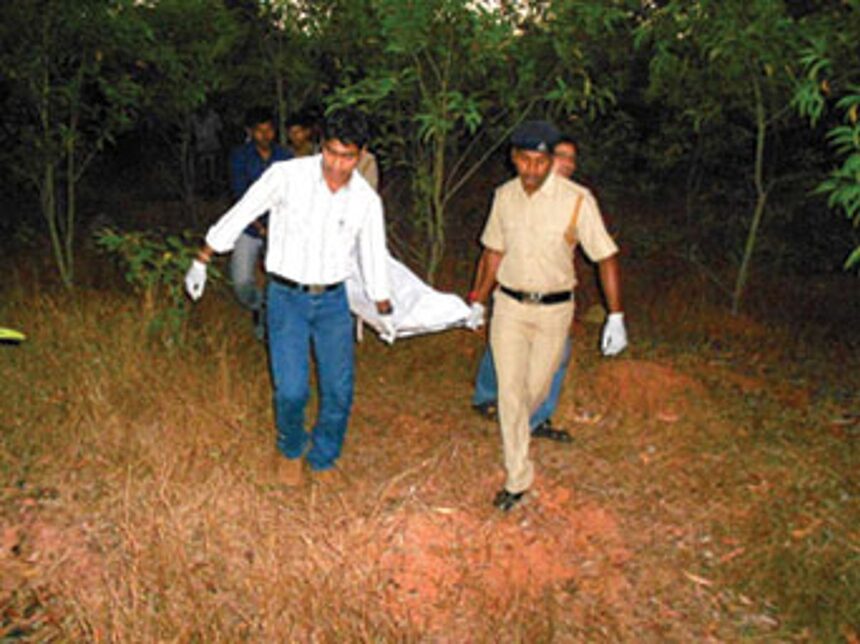 Police recover the body from the crime site.