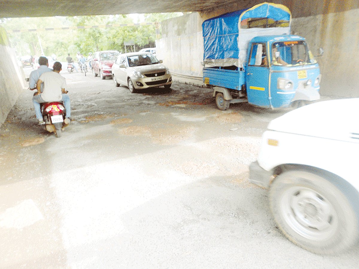 Potholes along the road under the railway bridge proceeding to Mangor.