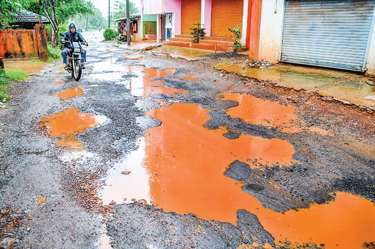 ROAD OF PAIN: A motorcyclist navigates through crater size potholes near Mitra bazaar in Caranzalem.