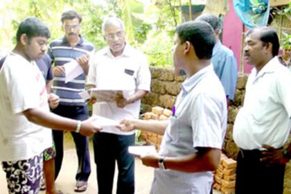 Sao Jose de Areal Sarpanch Julio Monteiro handing over a notice on a resident