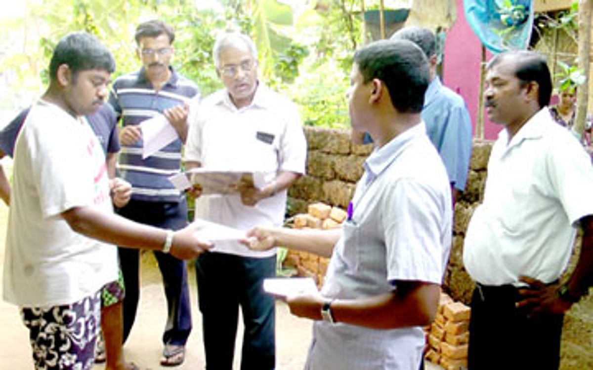 Sao Jose de Areal Sarpanch Julio Monteiro handing over a notice on a resident
