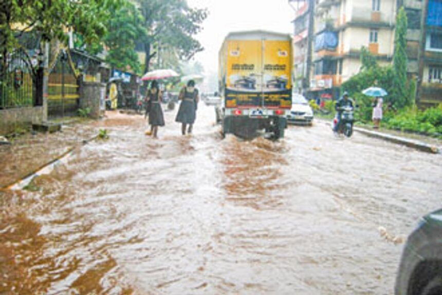School children wade through water on the Aquem road