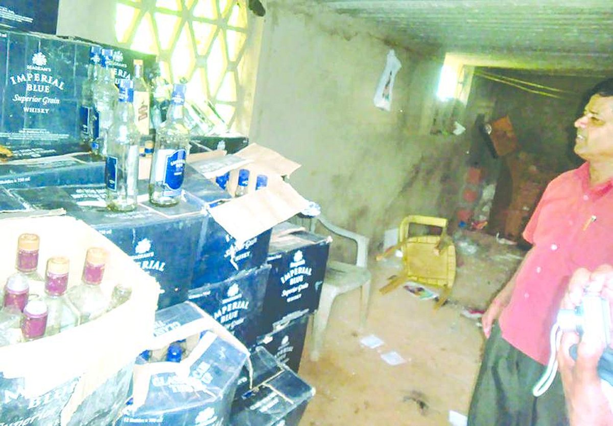 Superintendent of Excise Navnath Naik shows one consignment of illegal liquor.