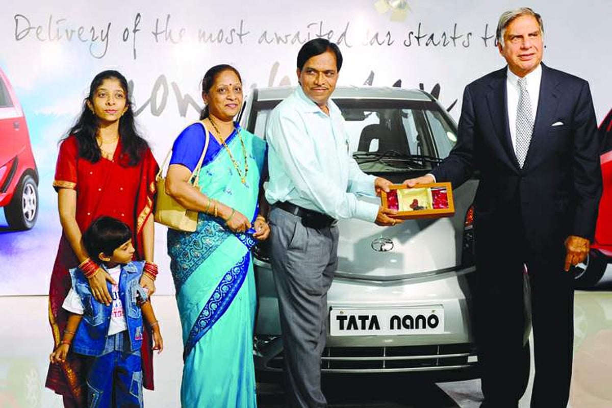 Tata Motors Chairman Ratan Tata  presents the keys to the first customer to take delivery of the Nano car, Ashok Raghunath Vichare, accompanied by his family, in Mumbai on Friday.