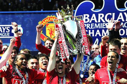 The Manchester United team celebrates with the English Premier League trophy after drawing 0-0 with Arsenal in the English Premier League football match at Old Trafford, Manchester, north-west England.