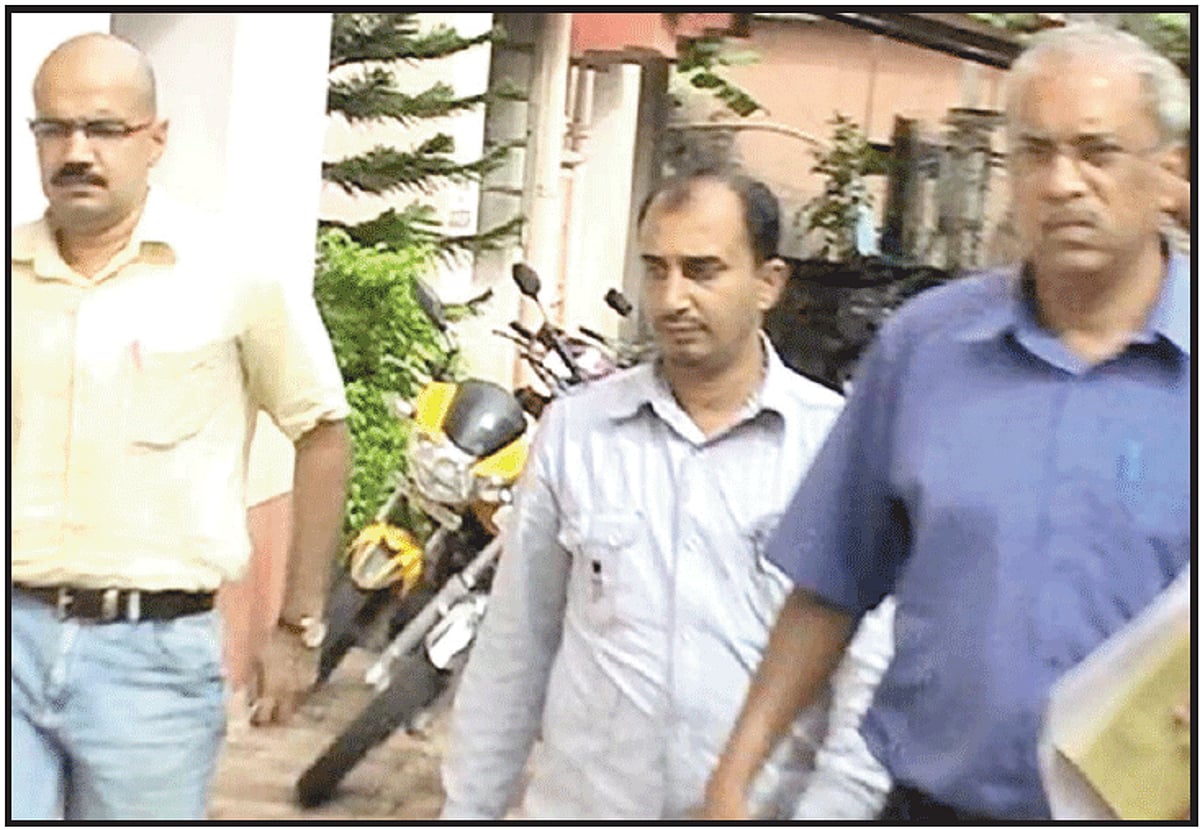 The accused (centre) is escorted by custom officials.