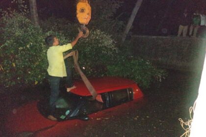 The car being removed from the culvert with the help of a crane.