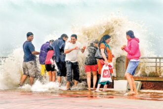 Tourists get drenched as huge waves during high tide batter the Dona Paula jetty on Monday.