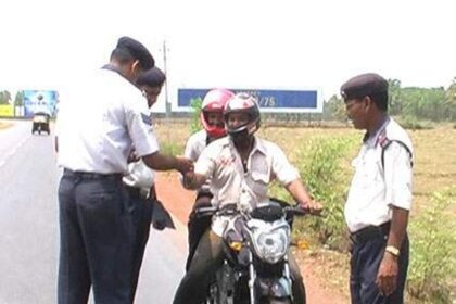 Two traffic police officers offer motorcyclists sweets for abiding rules at Margao on Saturday.  Photo by Santosh Mirajkar