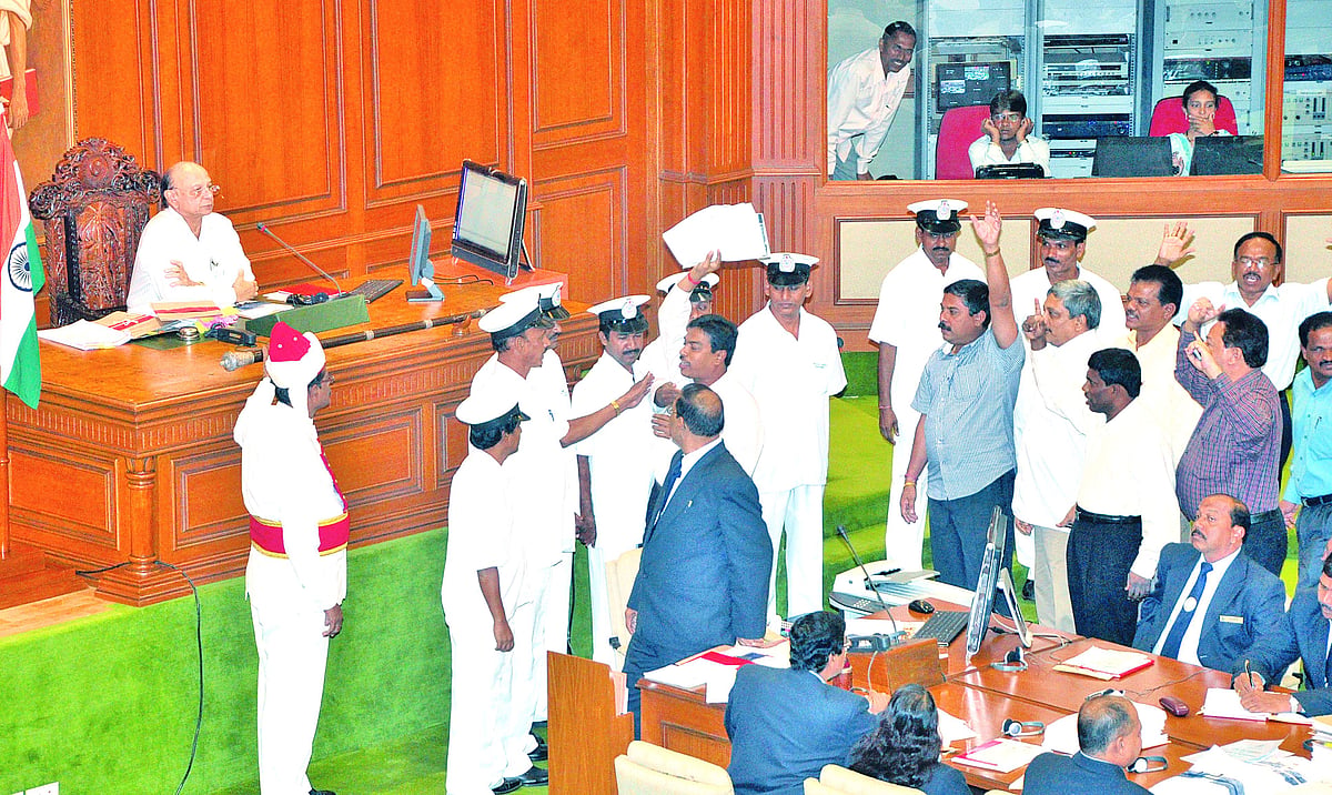 UP-IN-ARMS: Opposition MLAs rush towards the well of the House shouting slogans in support of their demand for a CBI probe into the police-drug mafia nexus even as Speaker Pratapsing Rane looks on.