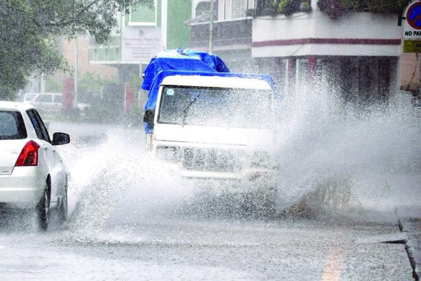 Vehicles drive through flooded Panjim roads splashing the waters all over. Heavy rains throughout Thursday inundated most of the city roads.