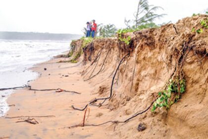 Visitors at Miramar beach look at the massive sand erosion due to the rough waves hitting the shore.
