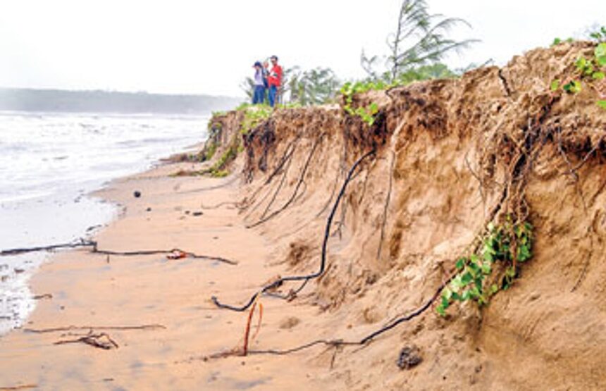 Visitors at Miramar beach look at the massive sand erosion due to the rough waves hitting the shore.