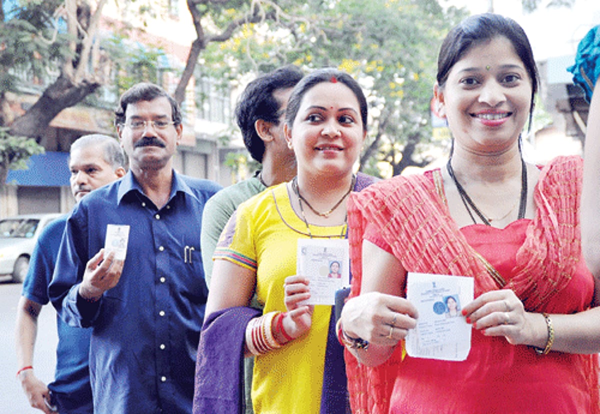 Voters display their photo identity cards before casting their vote at a booth in Panjim on Saturday.