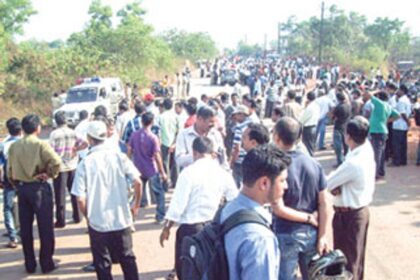 Workers gather at the entry point of Kundaim Industrial Estate on Thursday.
