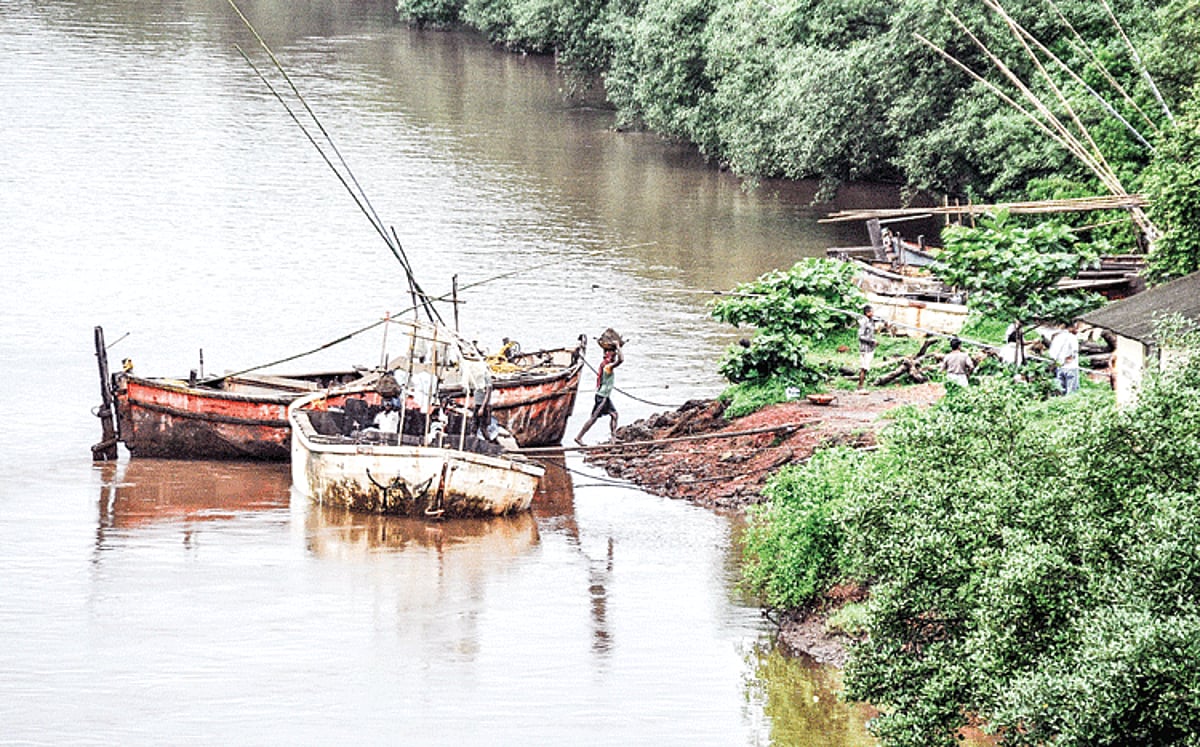 Workers unload sand from canoes below the Banastarim bridge on Saturday.
