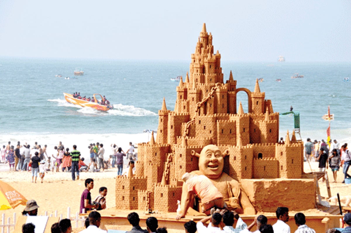 World Masters People's Champion Simon Smith sculpts the tallest sand castle ever made in India (20 feet high)  while tourists enjoy a boat ride in the background at Calangute beach, on Sunday. The sculpture will be on display until May .